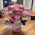 soft pink peonies and lisianthuses in floral hatbox