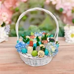 Gourmet baby gift basket with a mix of treats and floral accents