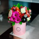 Fruit Gift Box featuring fresh strawberries, plums, and Gerbera flowers