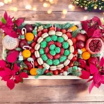 Holiday gift box with assorted fruits, chocolate strawberries, macarons, and flower arrangements for Christmas celebrations.