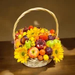 Elegant Fall gift basket with fresh and dried fruits, chocolate-covered strawberries, and pumpkin-flavored macarons