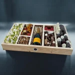 An extra-large corporate gift box packed with French macarons, nuts, and assorted cheeses.