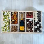 A generous gift box filled with various cheeses, dried fruits, and chocolate-covered bananas and pineapples.