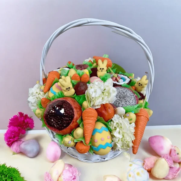 Joyful Easter Gift Basket featuring a mix of flowers, fresh fruits, chocolate-covered marshmallow bunnies, and chocolate eggs with surprises