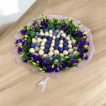 Personalized bouquet in the shape of a letter with fresh flowers and strawberries