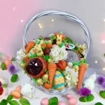 Celebratory Easter Basket with floral elements, fresh fruits, chocolate-covered strawberries, and festive carrot cake pops