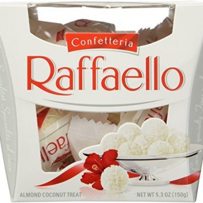 Close-up of a Raffaello confection, showcasing its delicate white exterior, coconut flakes, and hint of the almond center.