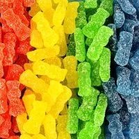 Close-up of colorful Sour Patch Kids candies, showcasing their kid-shaped forms coated in tangy sugar crystals.