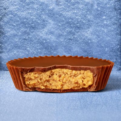 Close-up of a Reese's Peanut Butter Cup, revealing its creamy peanut butter center surrounded by milk chocolate.