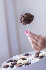 Circle box with chocolate flowers, filled with marshmallows and strawberries.