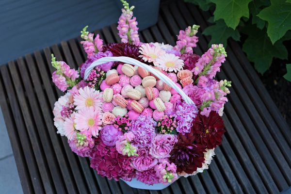 Food gift basket highlighting chocolate strawberries and artisanal macarons.