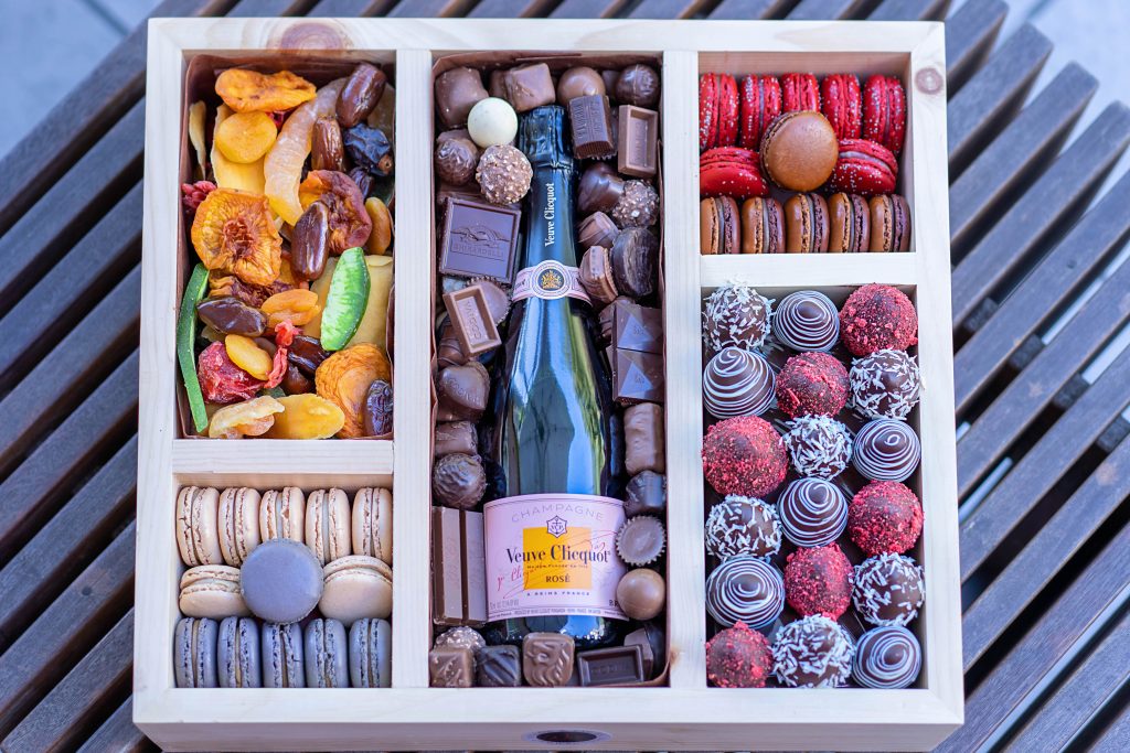Elegant holiday gift box with champagne and gourmet treats.