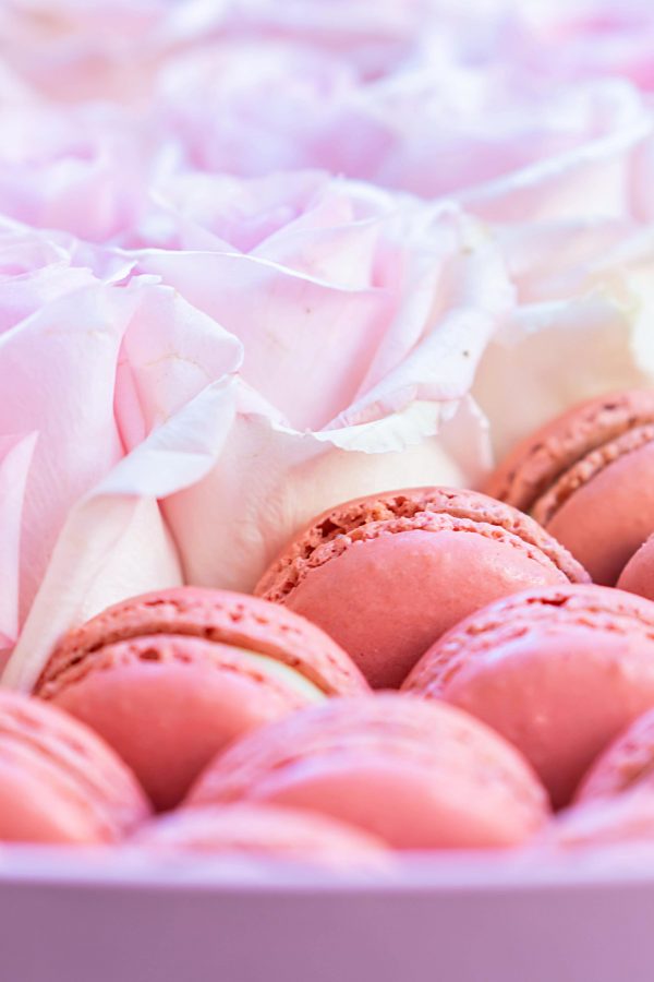 A heart-shaped box partitioned for roses on one side and macarons on the other.