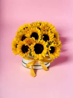 A hatbox brimming with sunflowers, designed to convey warmth and happiness, positioned in a natural light setting to enhance the vivid yellow hues.