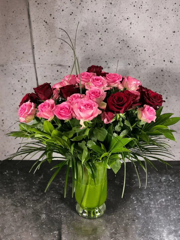 Stunning mix of pink and red roses elegantly presented in a modern vase