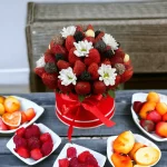 A stunning birthday fruit bouquet that pairs strawberries with Ferrero Rocher chocolates, accented with blueberries and flowers, for a memorable gift.