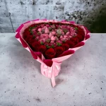 Manhattan bouquet combining fresh roses with chocolate-covered treats.