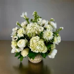 Timeless white flower bouquet featuring roses, hydrangeas, and peonies.