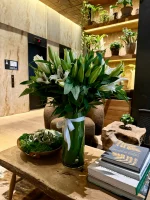 Fresh white lilies and green leaves artfully arranged in a vase.