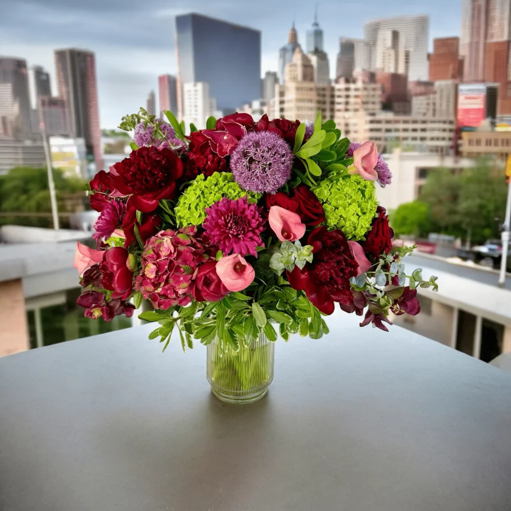 Fresh eucalyptus and vibrant red flowers in a deluxe vase.