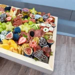 Gourmet charcuterie box with a variety of dried fruits, pretzels, and crackers