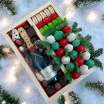 Festive holiday gift box with chocolates, nuts, and macarons