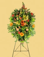 Detailed floral arrangement of carnations, snapdragons, and mums in the Golden Remembrance Spray.