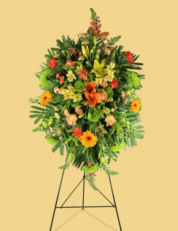 Detailed floral arrangement of carnations, snapdragons, and mums in the Golden Remembrance Spray.