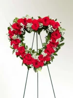 Detailed shot of red carnations and roses in a heartfelt tribute.