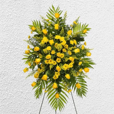 Side angle showcasing yellow flowers and lush greenery in a standing spray.