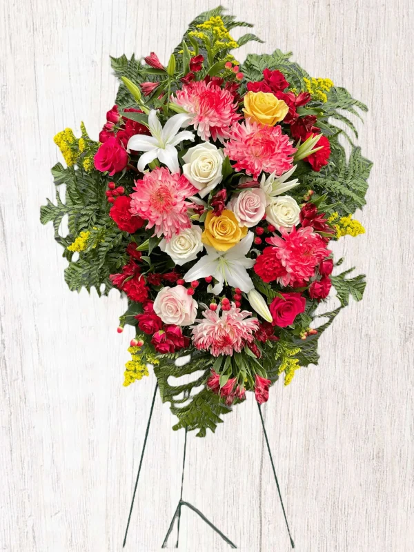 Vibrant red roses and white lilies in a heartfelt funeral arrangement.