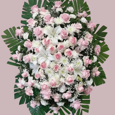 Side angle of pink and white flowers in a funeral standing spray.