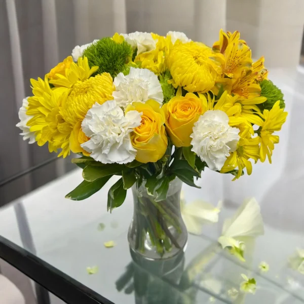 Soft white carnations complementing bright yellow sunny flower mix