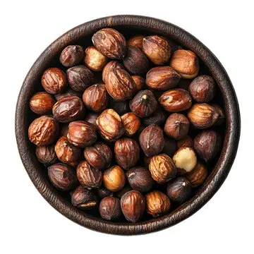 Pale, round candlenuts resting on a wooden bowl, highlighting their high oil content used in Southeast Asian cooking.