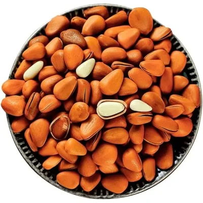 Small, reddish brown, pale cedar nuts in a bowl, often used in Russian cuisine.