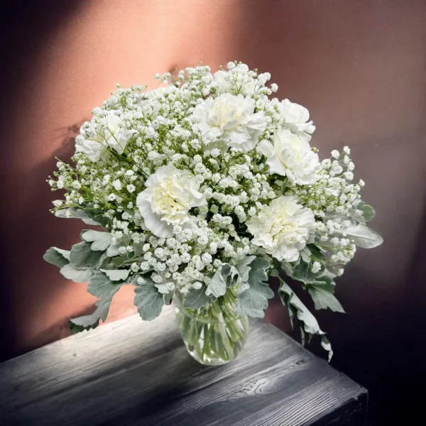 Side view of a carnation bouquet placed on a wooden table