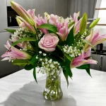 Lovely mix of pink lilies and pink roses by a window