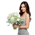 Smiling woman holding arrangement of white flowers with silver leaves