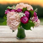 Hand-arranged purple roses and pink hydrangea bouquet