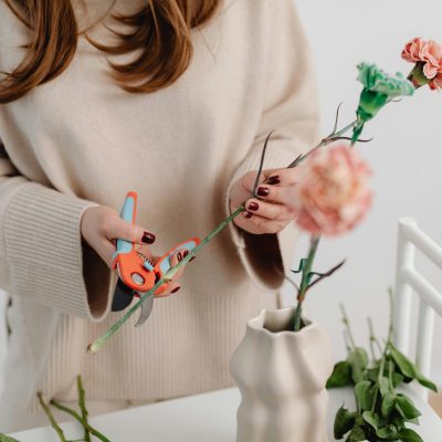 Fresh flower in a vase with trimmed stems by a woman and clean water to keep them fresh longer.