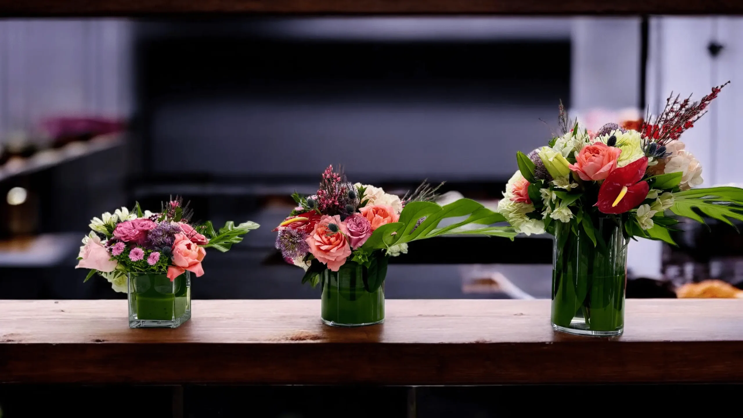 3. Colorful flowers in a clear glass vase near a company entrance
