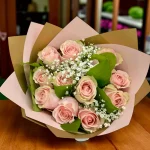 Fresh pink roses tied together in an elegant hand bouquet