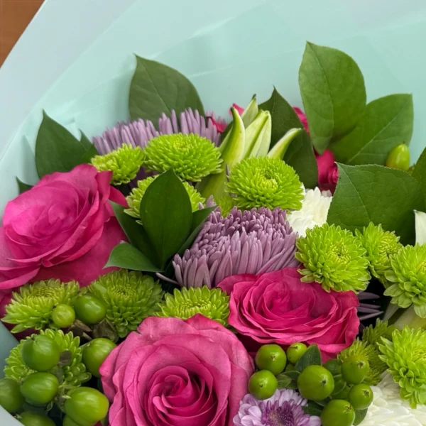 Close-up of pink roses and green button mums in anniversary bouquet