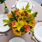 Warm mixed floral arrangement styled on a dining table