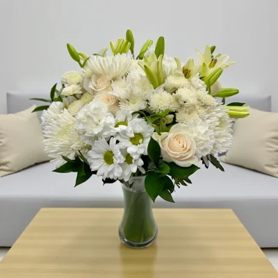 Soft white flower mix arranged in a vase on a table