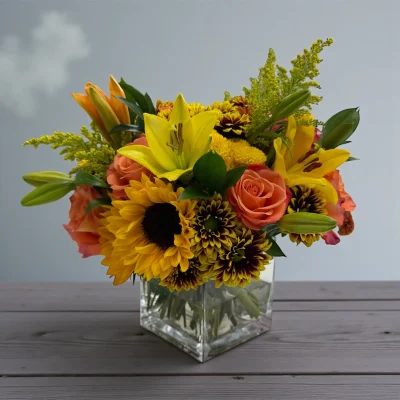 Warm yellow and orange mixed bouquet arranged on a wooden table