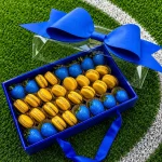 World Cup Sweden sweets box featuring chocolate dipped strawberries and macarons arranged in team colors
