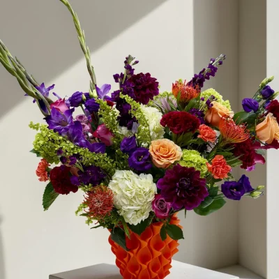Designer flower arrangement in NYC with purple, orange, green and white flowers