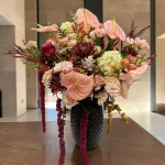 Close-up of premium pink anthuriums, roses, hydrangeas, and specialty chrysanthemums in The Fifth Avenue Statement arrangement