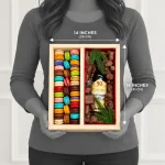 Person holding a 16 by 14 inch wooden macaron and chocolate gift box to demonstrate its size